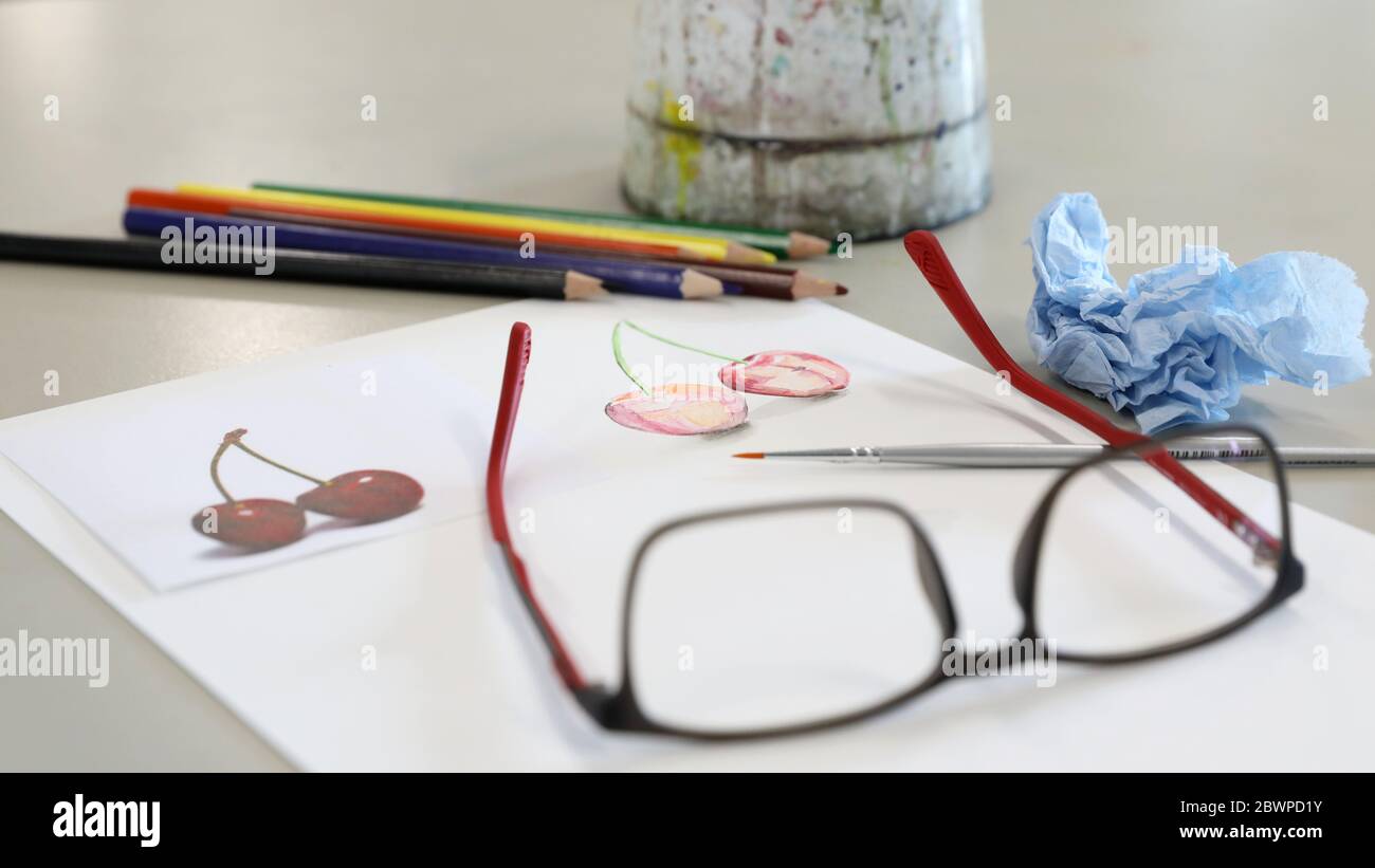 attrezzature per arti visive per la dimostrazione in classe da parte dell'insegnante. Le vernici acquose pennellano carta e matite su una scrivania o un tavolo nella sala d'arte Foto Stock