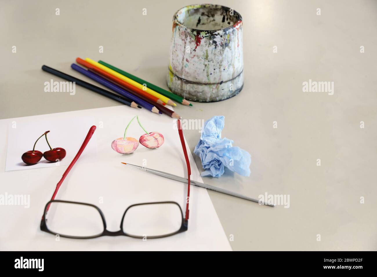 attrezzature per arti visive per la dimostrazione in classe da parte dell'insegnante. Le vernici acquose pennellano carta e matite su una scrivania o un tavolo nella sala d'arte Foto Stock