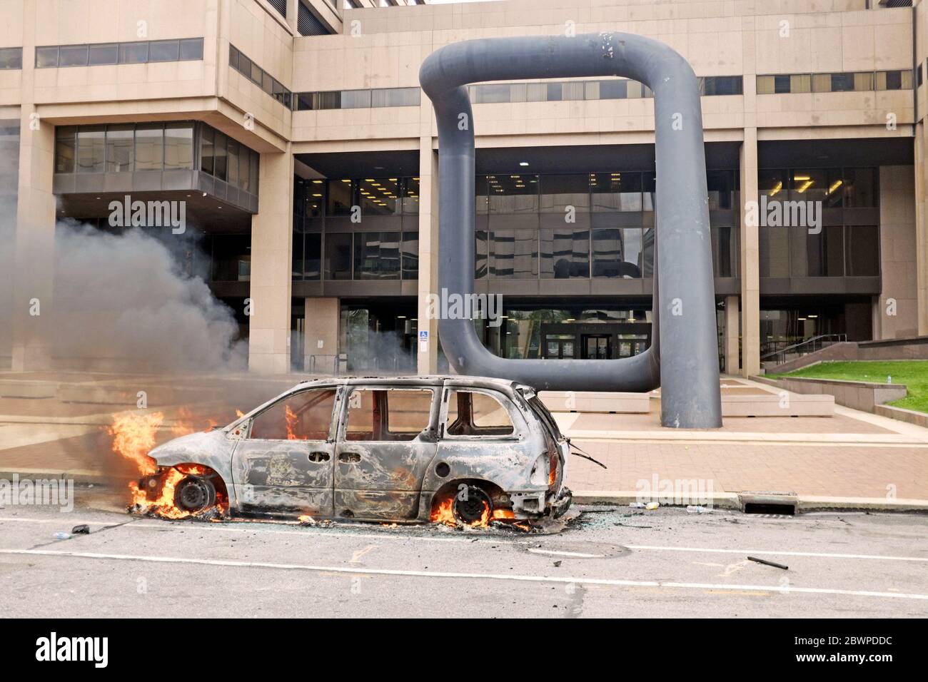 Un'auto vandalizzata messa al fuoco si trova fuori del complesso del Cleveland Justice Center a seguito della protesta di George Floyd del 30 maggio 2020. Foto Stock