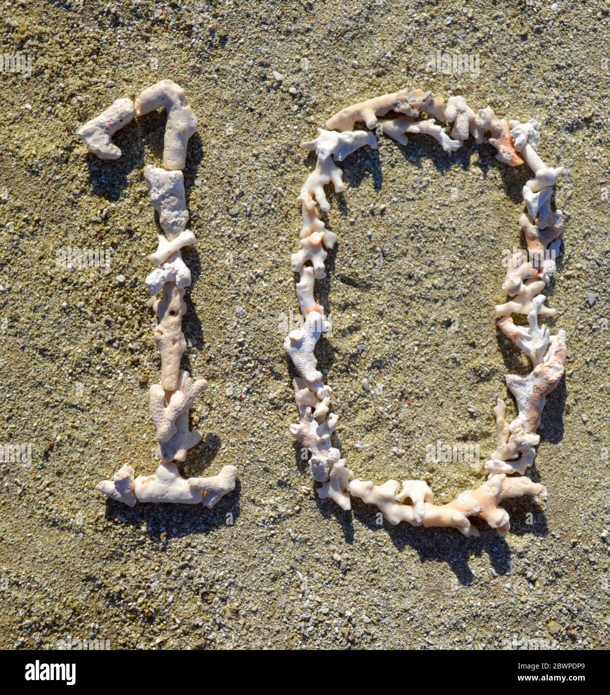 Il numero 10 (dieci) si è disteso su una spiaggia sabbiosa in pezzi di corallo bianco, sbiancato dal sole, morto sull'isola della Grande barriera Corallina di Heron. Foto Stock