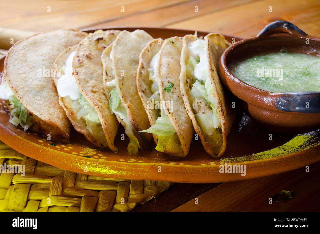 Tacos dorados messicani e salsa verde Foto Stock