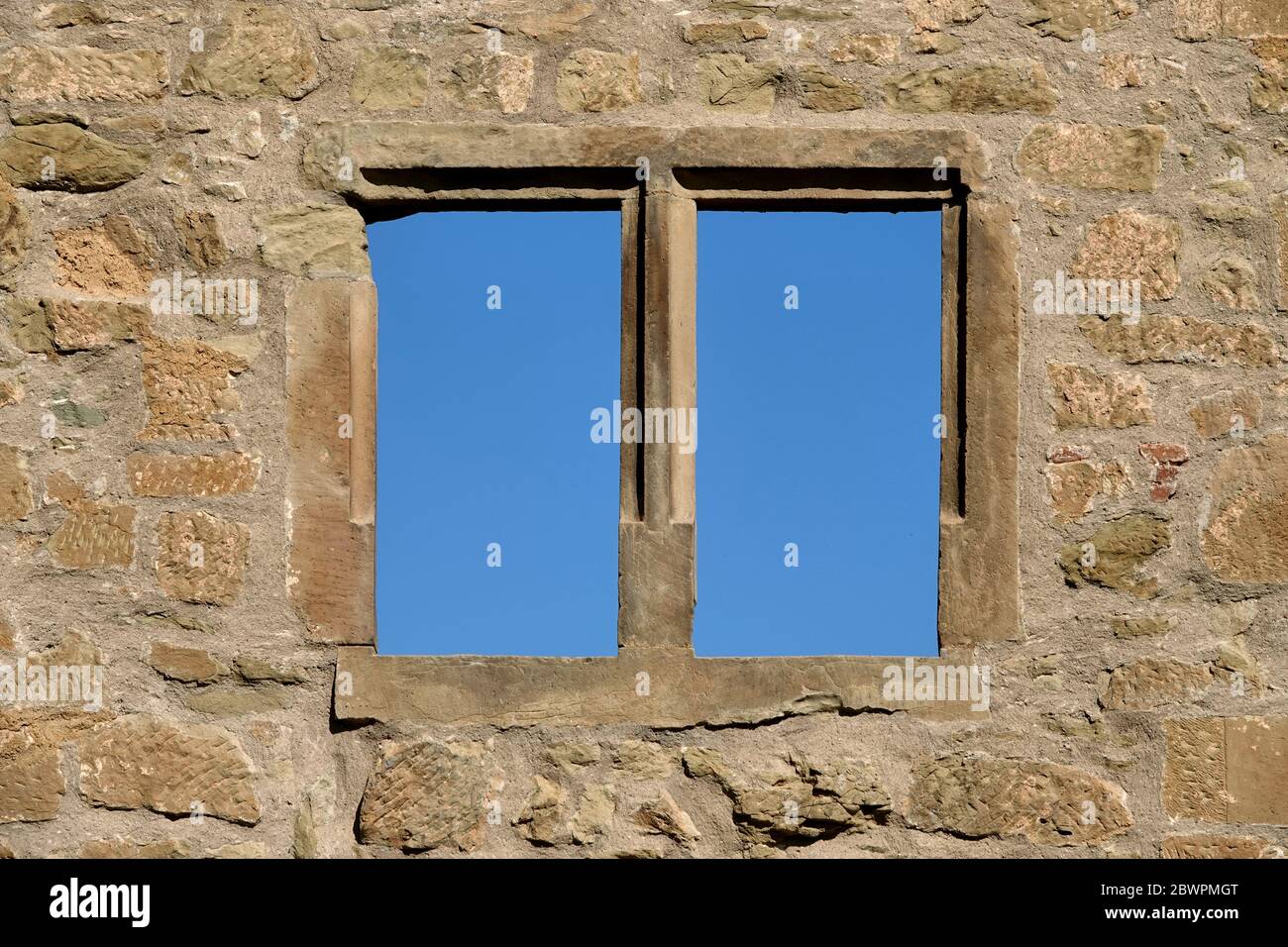 Finestra marrone in un castello di mattoni, fotografata full frame, cielo blu, prospettiva profonda. Germania. Foto Stock