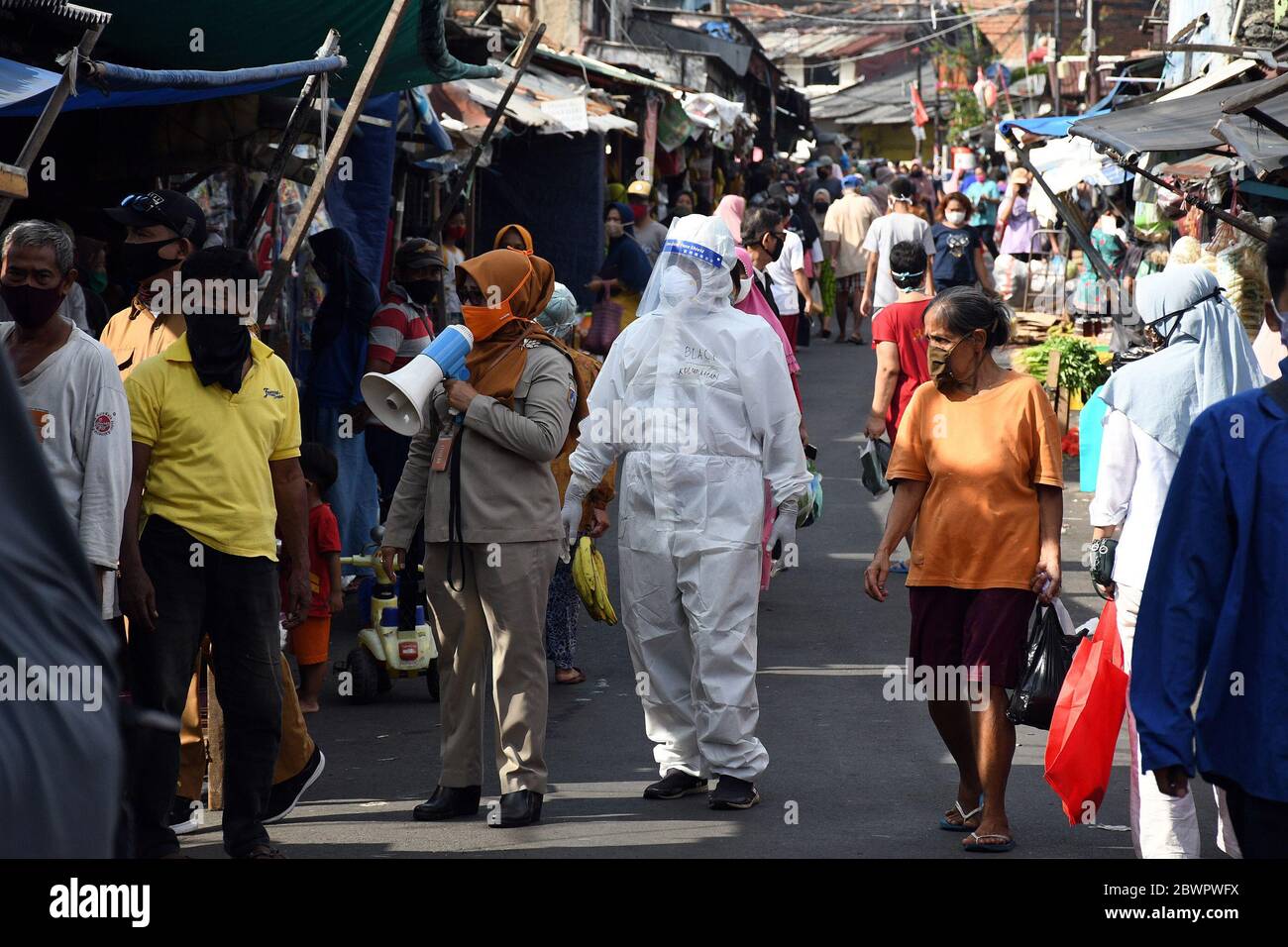 Pechino, Indonesia. 2 Giugno 2020. Un funzionario sanitario utilizza un altoparlante per chiedere alle persone di fare rapidi test in occasione dell'epidemia di COVID-19 in un mercato tradizionale di Giacarta, Indonesia, il 2 giugno 2020. Credit: Dasril Roszandi/Xinhua/Alamy Live News Foto Stock