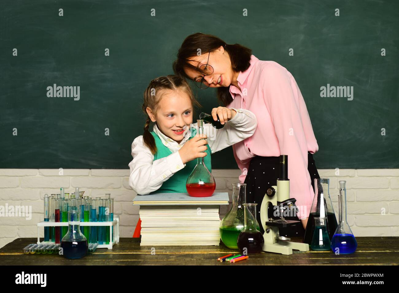 Il mio esperimento chimico. Lezioni di chimica scolastica. Scienza chimica. Bambino della scuola elementare. Istruzione. Esperimenti di biologia al microscopio Foto Stock