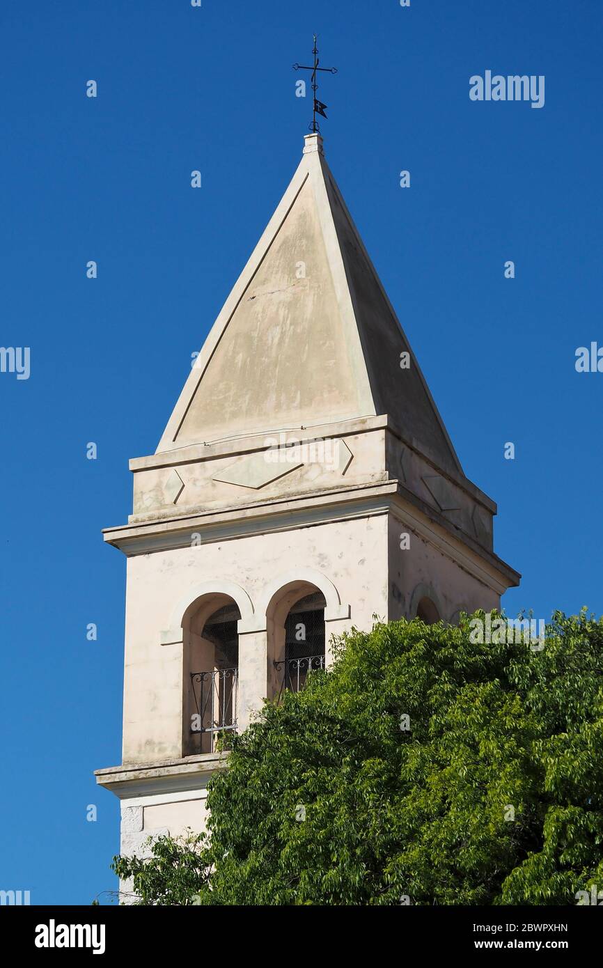 la torre della chiesa sopra l'albero, con il cielo blu sullo sfondo Foto Stock
