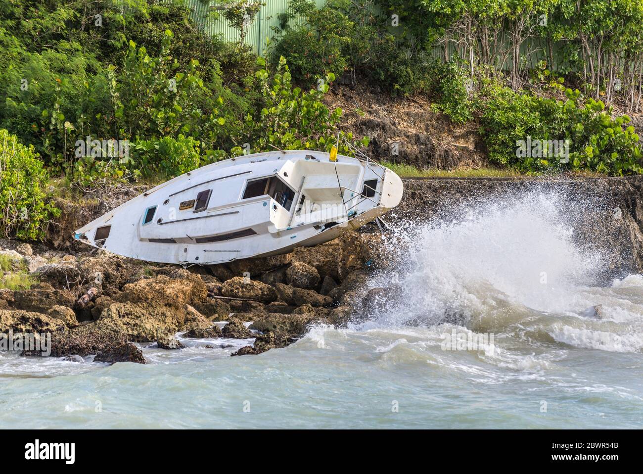 Una barca a vela è stata distrutta e abbandonata sulla riva dopo un uragano  - il Gosier in Guadalupa, Caraibi Foto stock - Alamy