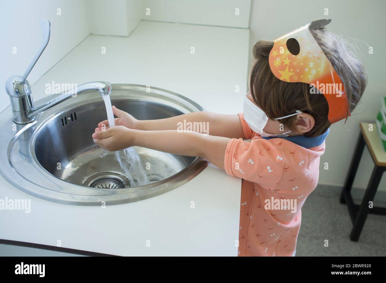 3 anni ragazzo lavando le mani al lavello sanitario. Concetto di abitudini igieniche durante la pandemia di Covid-19. Foto Stock