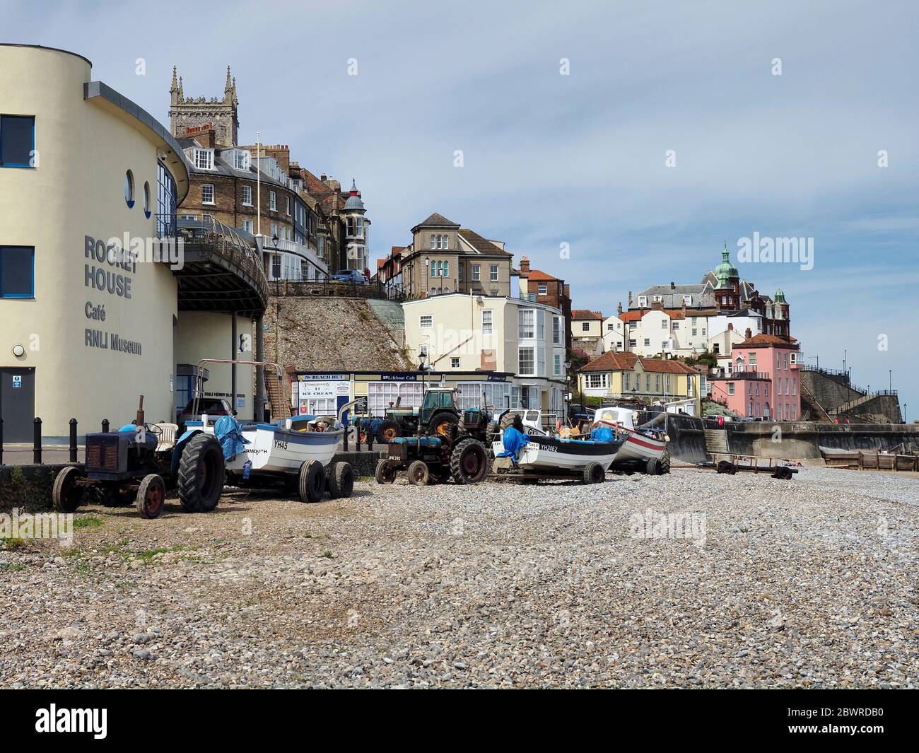 Cromer, Norfolk - barche di granchio trasportate fuori sulla spiaggia dalla Casa del Rocket durante l'epidemia di Covid-19 con città di Cromer dietro. Foto Stock