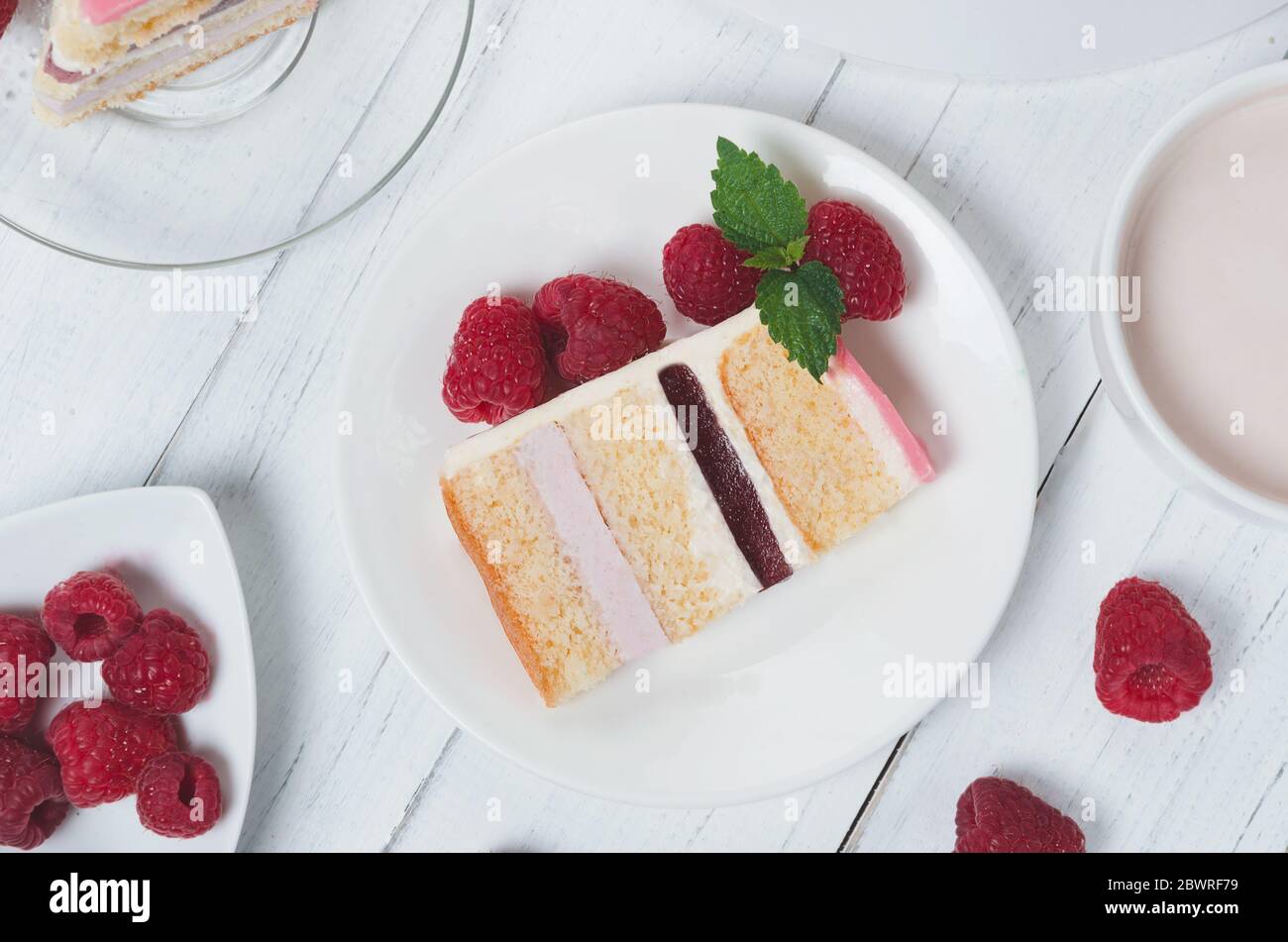 Pezzo di piatto di lampone in cakeon con lamponi intorno Foto Stock