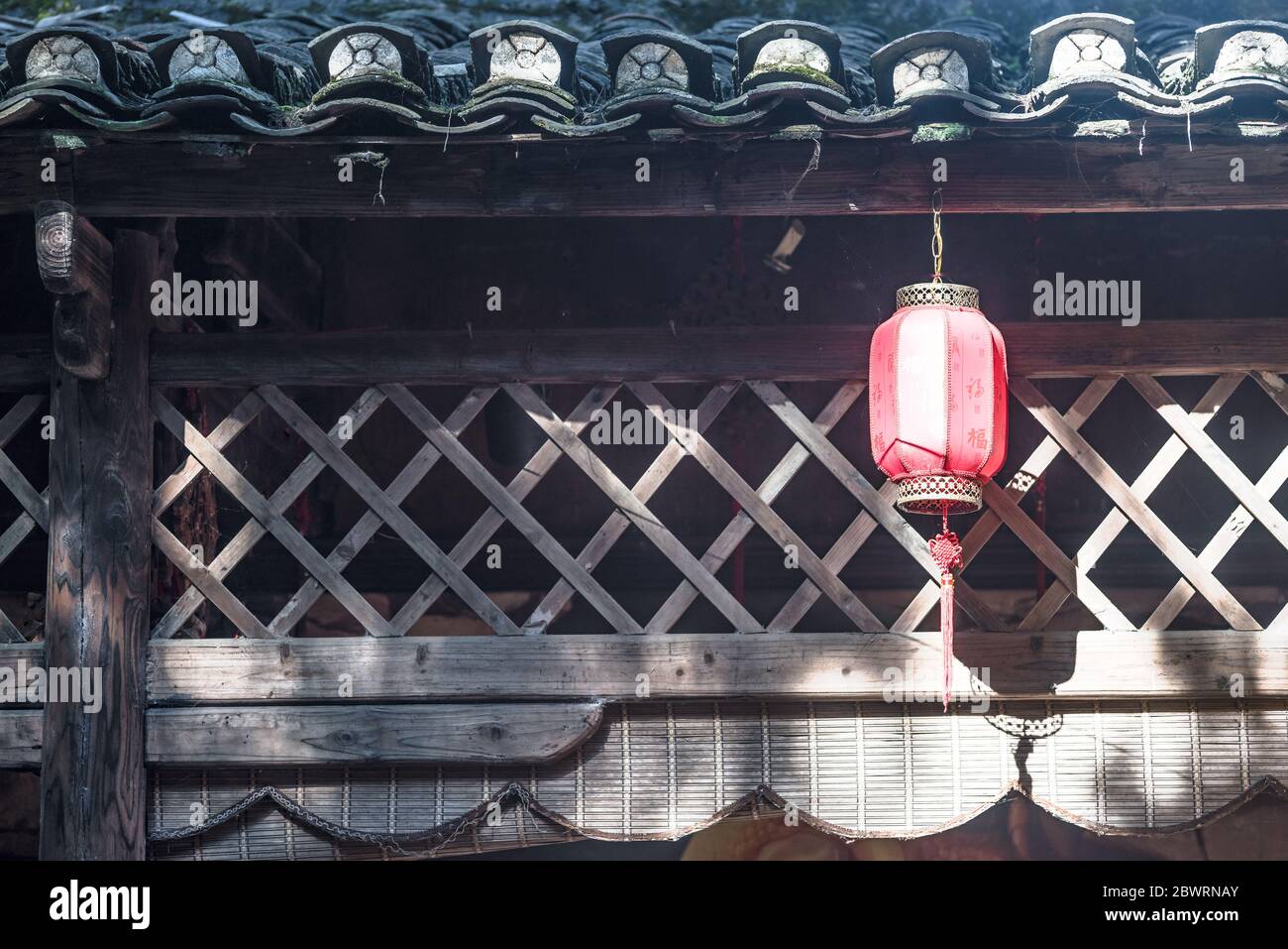 lanterna con caratteri cinesi significa 'felicità' su di essa, appesa su un'eave di antica casa cinese Foto Stock