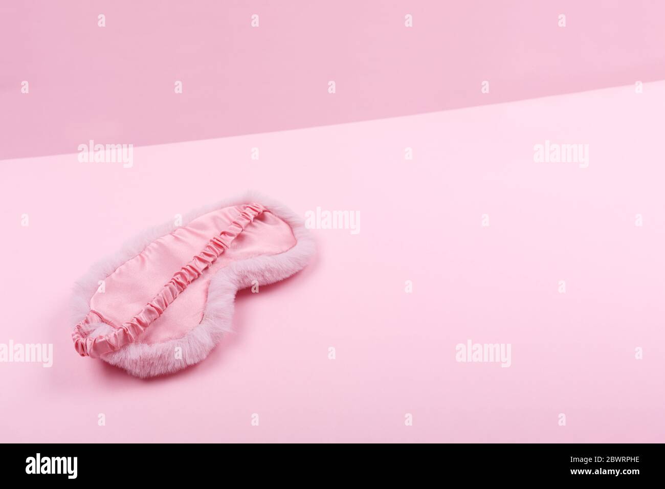 Bella maschera da sonno flaffy su goccia rosa duotone. Tempo di bellezza, autosocura e registro del sonno, concetto di tempo femminile. Posiziona per il testo Foto Stock