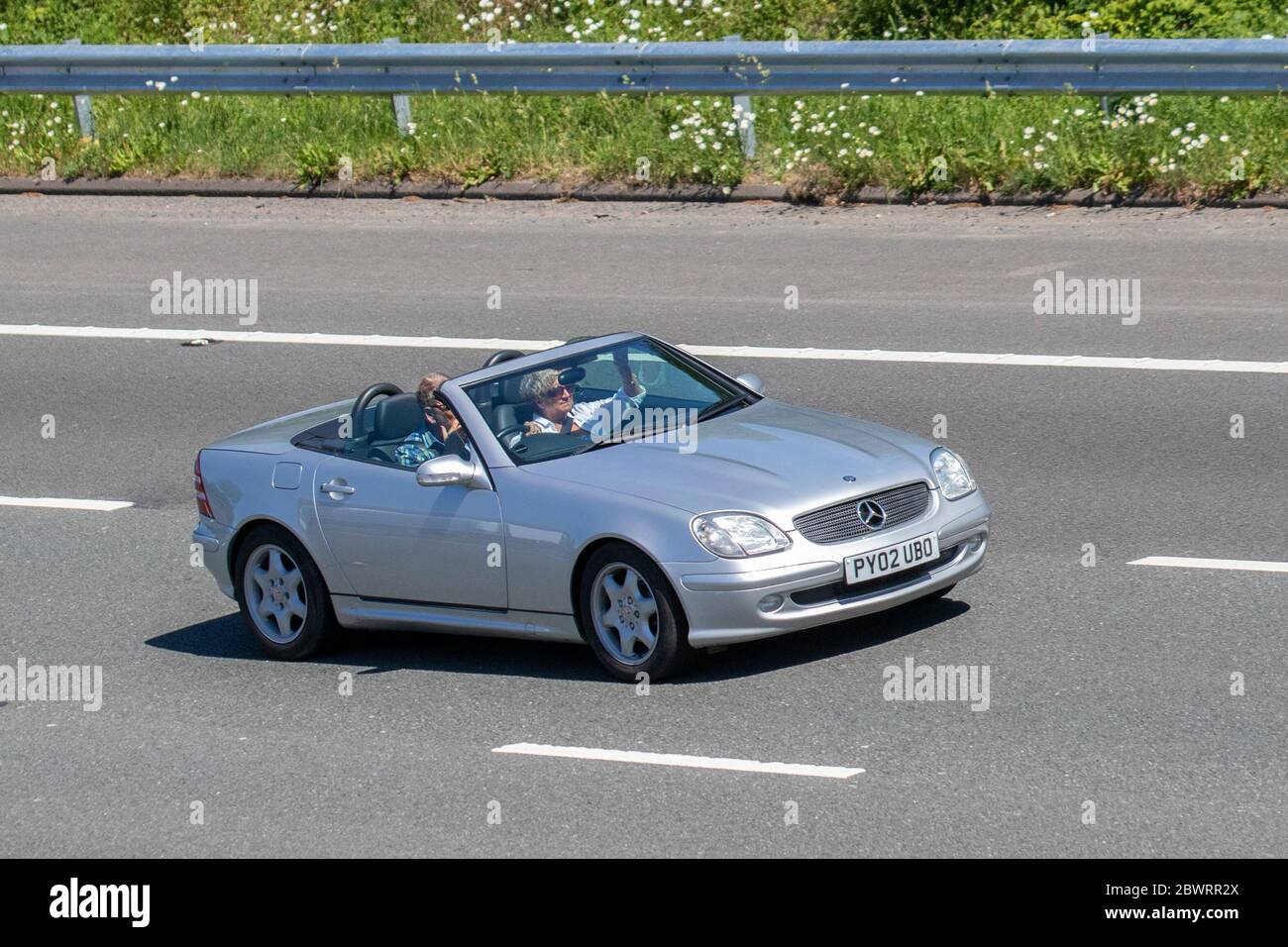 Mercedes Benz SLK 230 Kompressor Auto argento 2002; veicoli in movimento per traffico veicolare, convertibili, decappottabili, tetto apribile, roadster, cabriolet, auto a ridosso che guidano veicoli su strade del Regno Unito, motori, motori sull'autostrada M6 Foto Stock