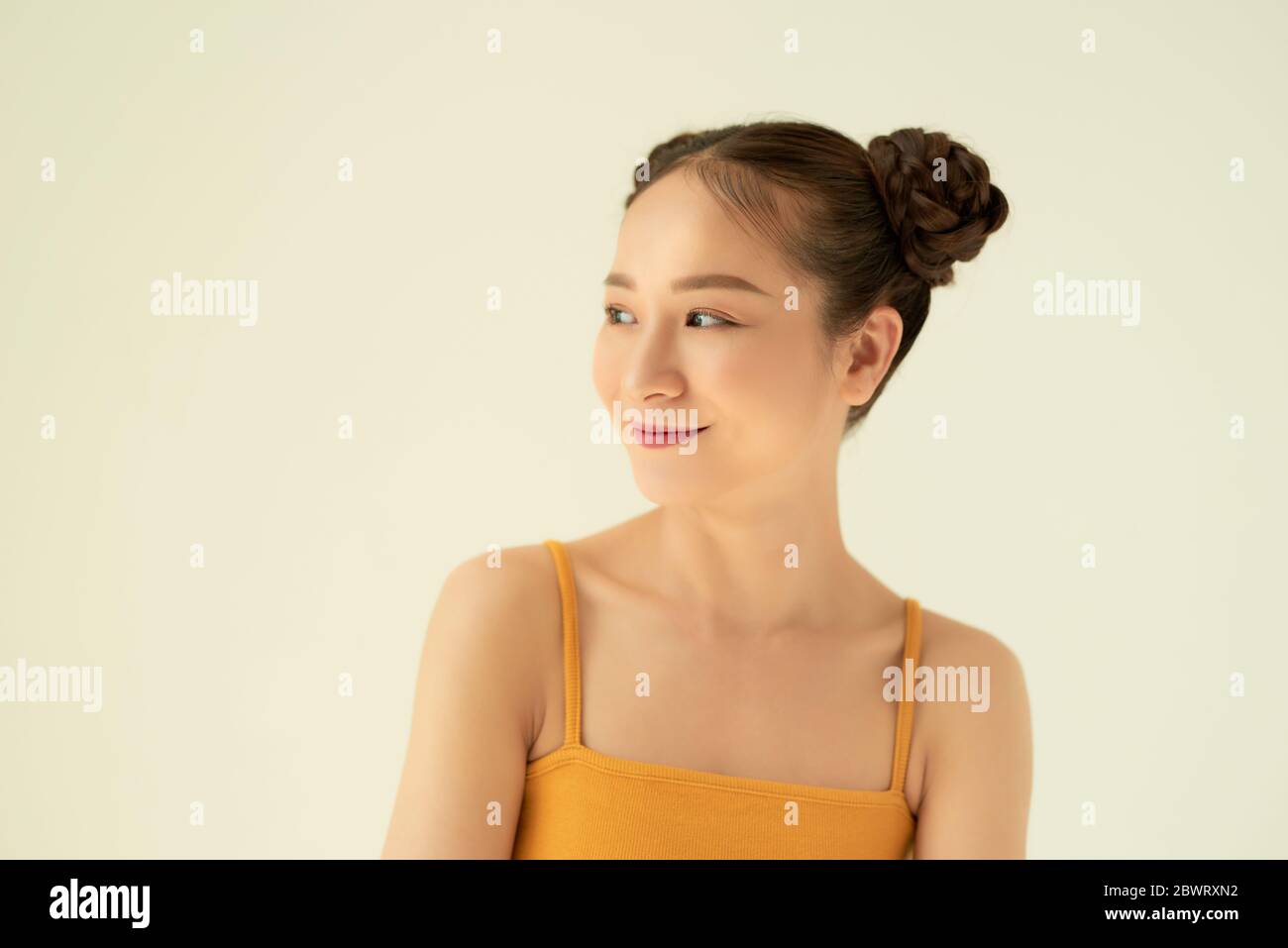 Ritratto di giovane ragazza asiatica cute con due consoli sullo sfondo chiaro. Foto Stock