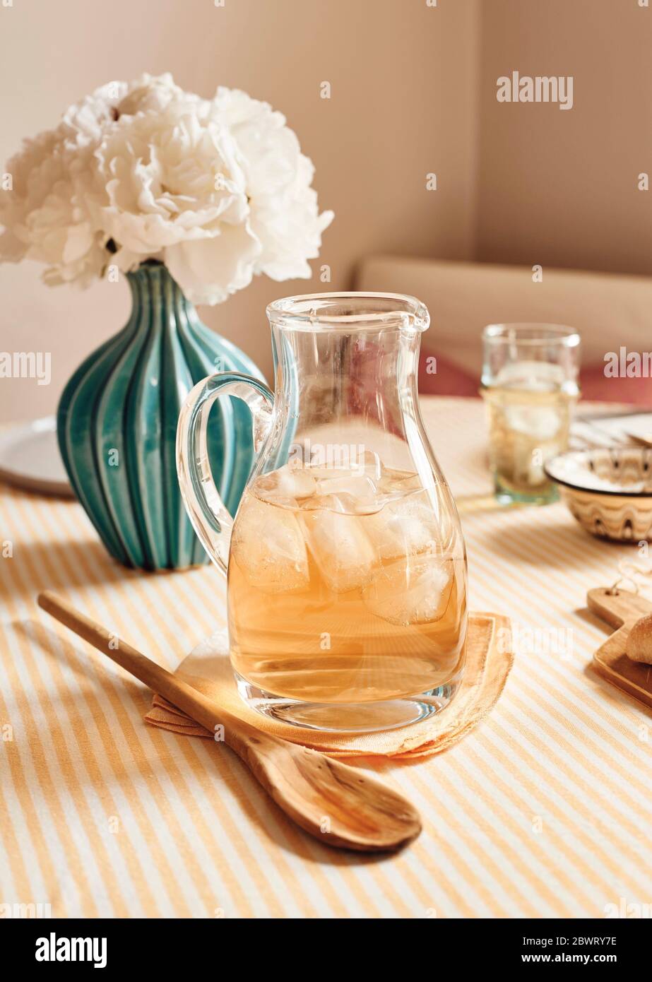 Un bel tavolo in cucina, vestito per brunch o una festa, con una caraffa di tè freddo. Foto Stock