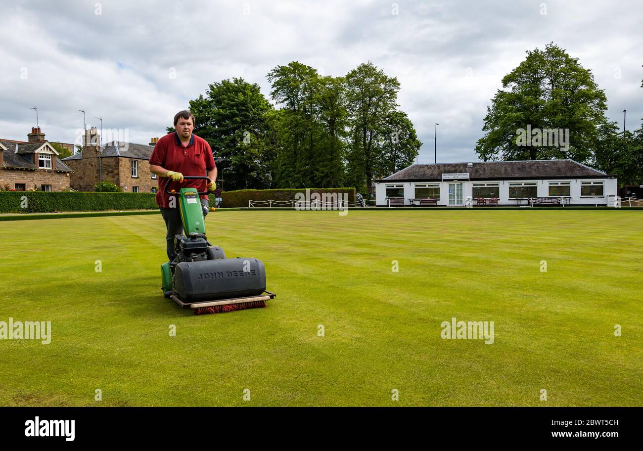 Haddington, East Lothian, Scozia, Regno Unito, 03 giugno 2020. Il più antico club di bowling della Scozia riapre dopo che le restrizioni di blocco sono state attenuate. Il club ha festeggiato il suo 300° anniversario nel 2009 e conta circa 75 soci. Nella foto: Mark McWilliams, uno dei membri del comitato del club che è attualmente impalletito, taglia l’erba in preparazione dei primi giocatori di oggi Foto Stock