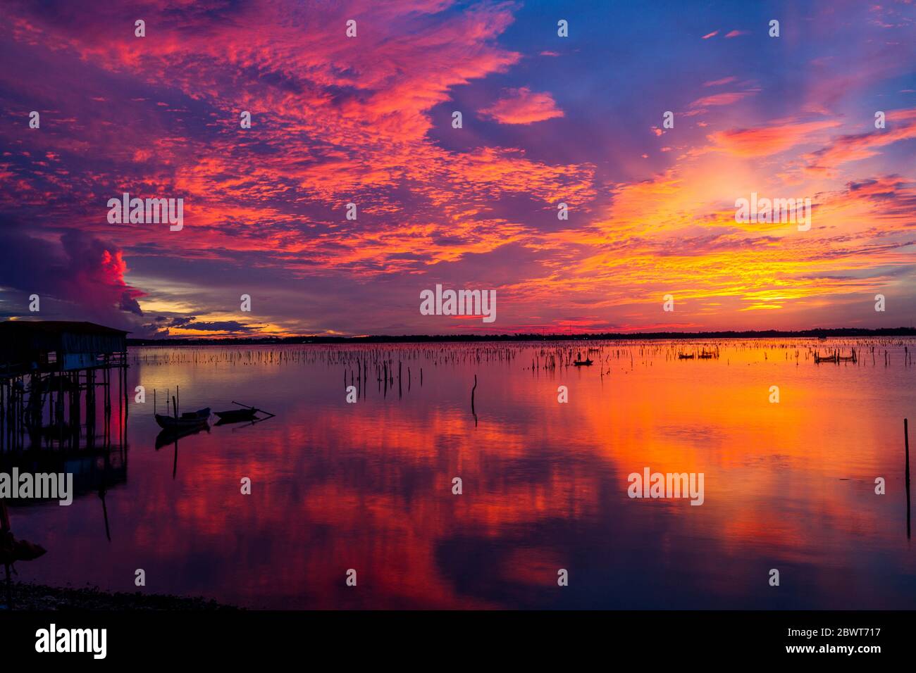 Meraviglioso paesaggio a Lap An laguna, Vietnam con la casa galleggiante, barca di legno e incredibile cielo colorato di alba. Foto Stock