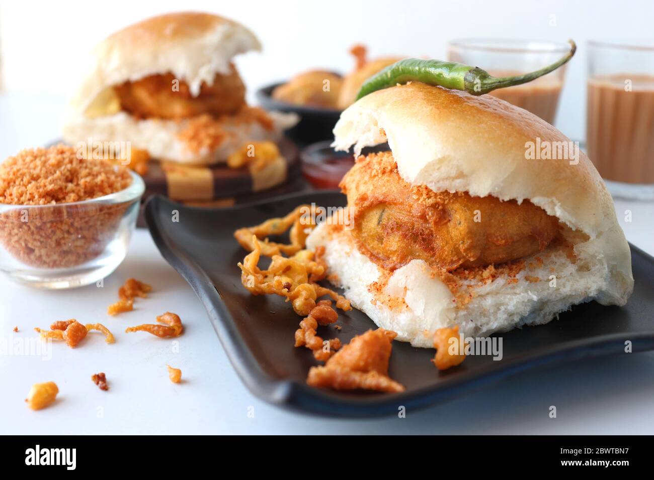 Vada pav o wada pao è un piatto vegetariano di fast food originario dello stato del Maharashtra. Famoso cibo di strada di Mumbai servito con chutney rosso. Foto Stock