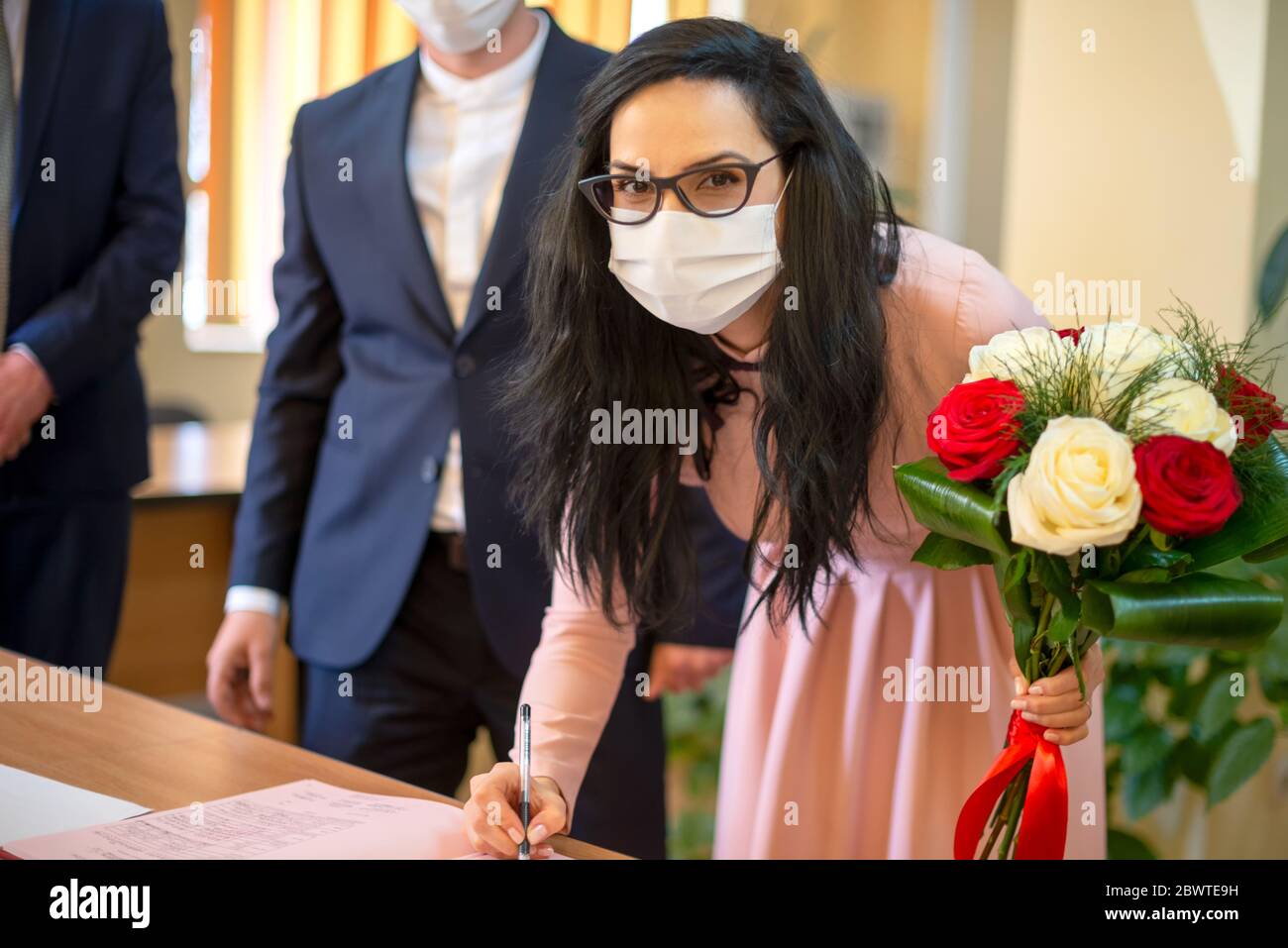 Galati, Romania - 10 aprile 2020:coppia innamorata appena sposata in una pandemia di covid. Firma certificato di matrimonio Foto Stock