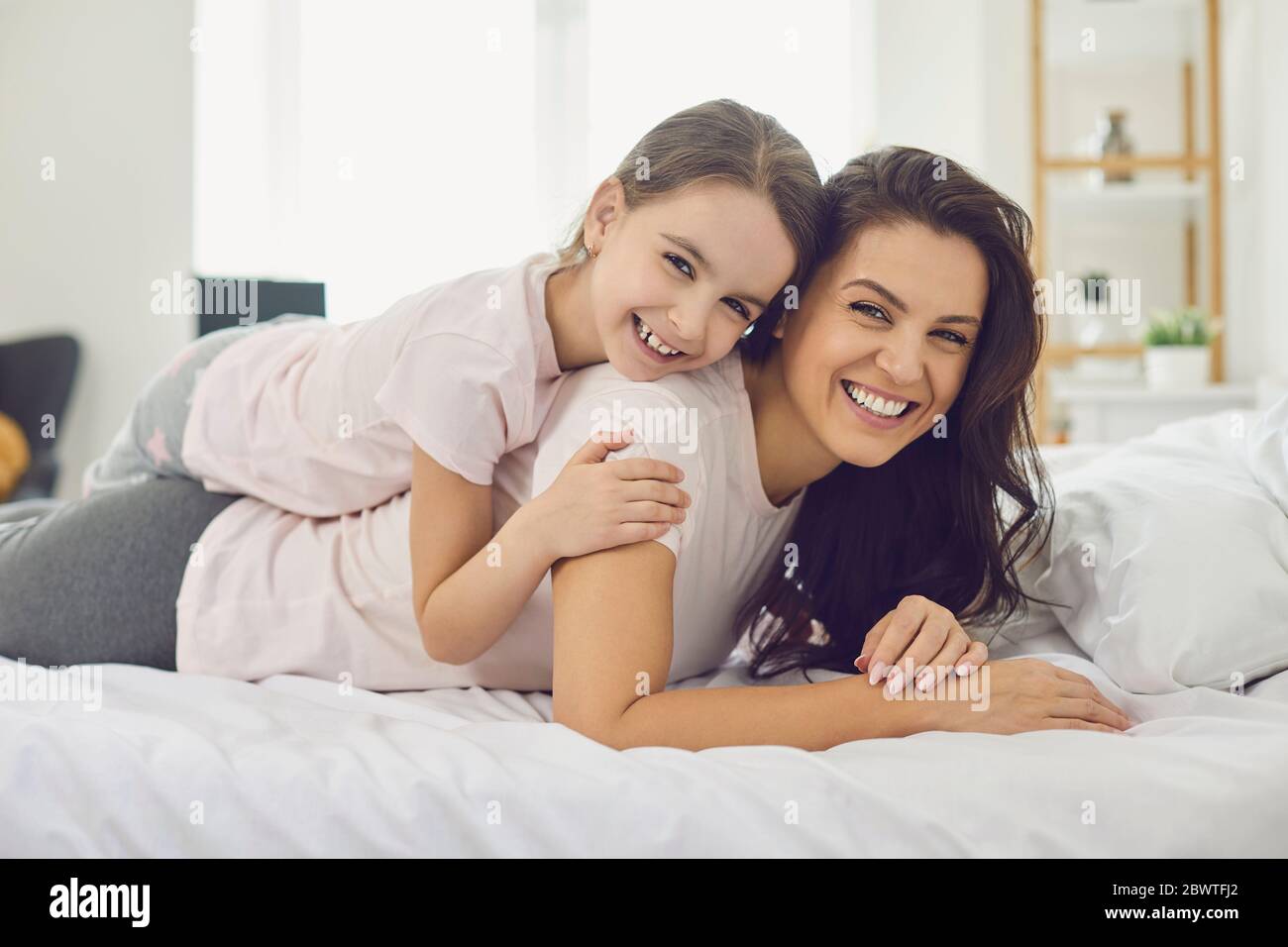 Happy madre Day.Ritratto di felice madre e figlia che si trova sul letto a casa. Foto Stock