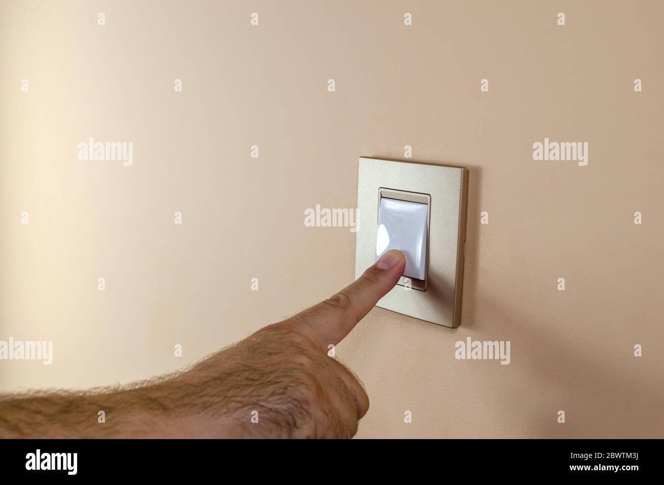 Premere manualmente il pulsante di un interruttore luci per accendere o  spegnere la luce Foto stock - Alamy