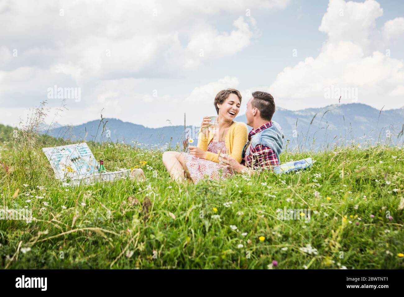 Felice coppia con un picnic su un prato in montagna, Achenkirch, Austria Foto Stock