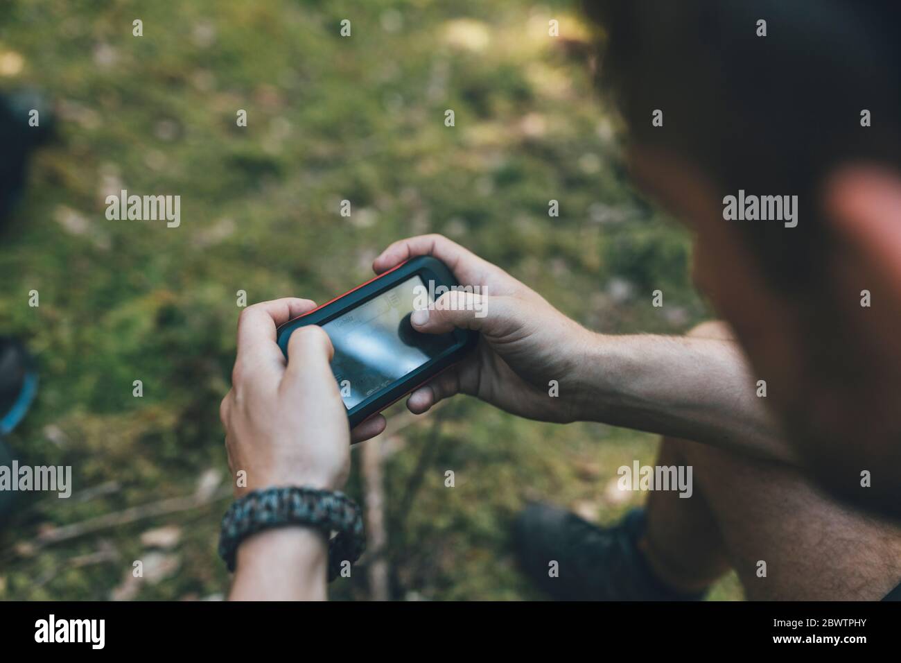 Giovane uomo che controlla il dispositivo di navigazione Foto Stock