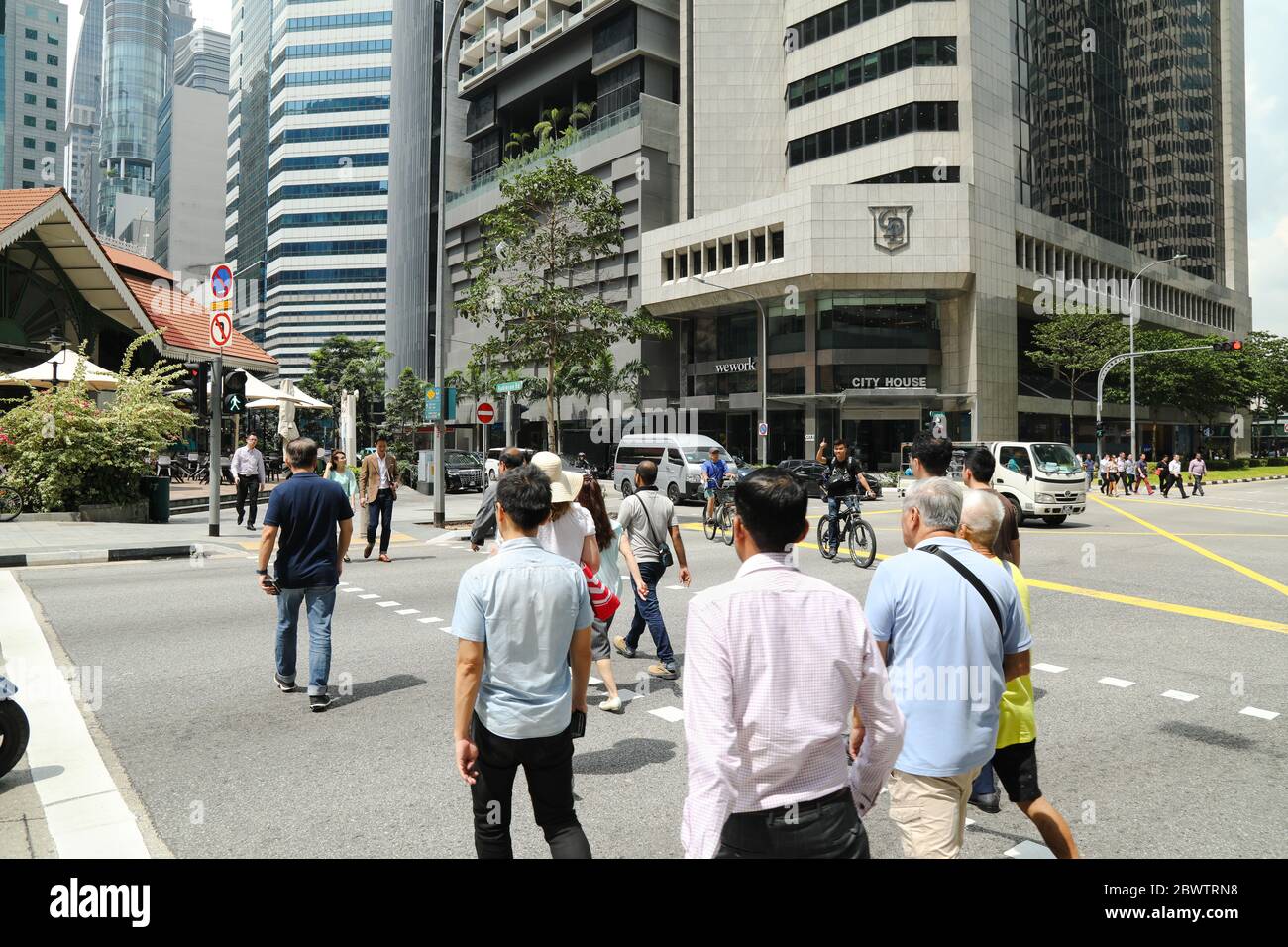 Persone che attraversano una strada nel quartiere centrale degli affari di Singapore. Foto Stock