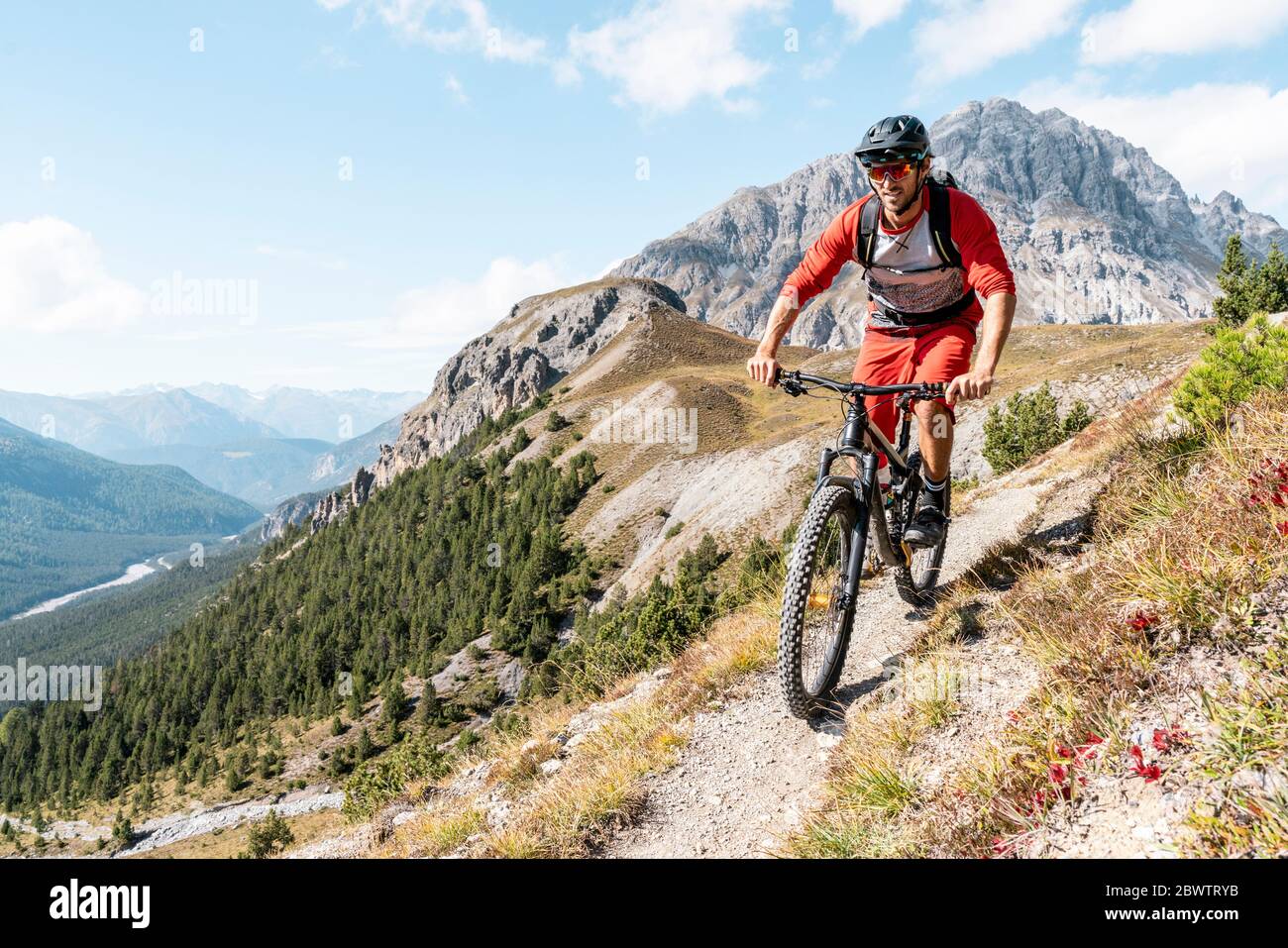 Uomo in mountain bike, Valle Munestertal, Grigioni, Svizzera Foto Stock