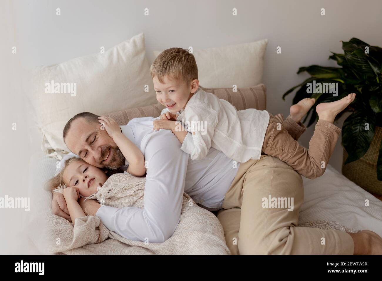 Ritratto di famiglia di felice padre e dei suoi due figli a casa Foto Stock