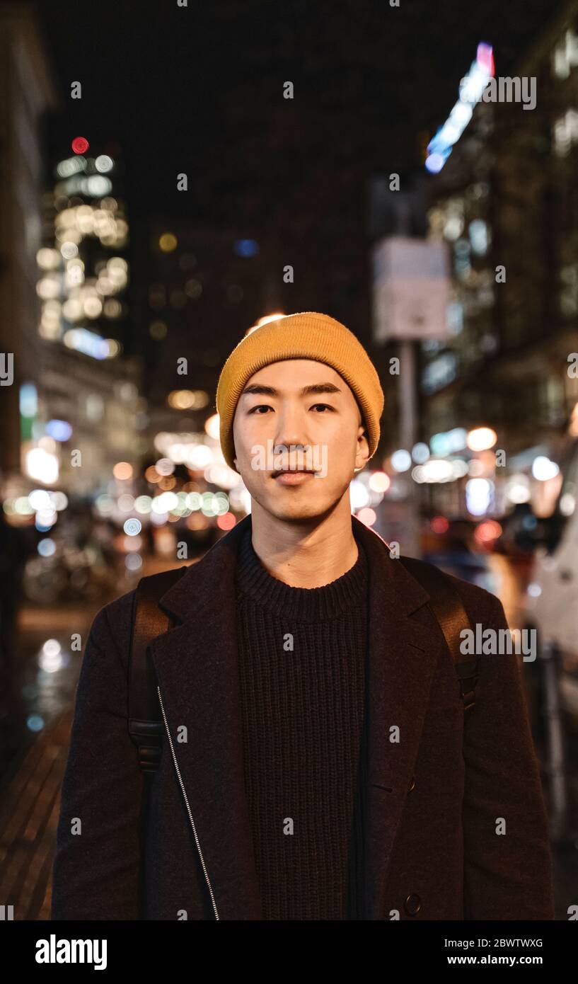 Ritratto di uomo elegante con cappello giallo in città di notte Foto Stock