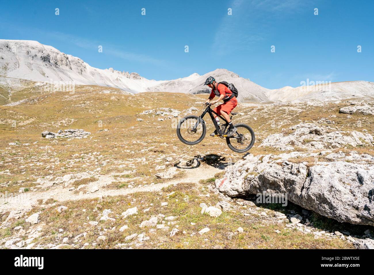 Uomo in mountain bike, Valle Munestertal, Grigioni, Svizzera Foto Stock