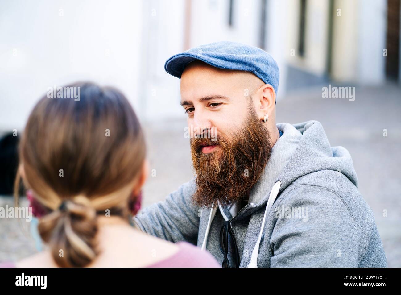 Ritratto di uomo bearded che guarda la donna in città Foto Stock