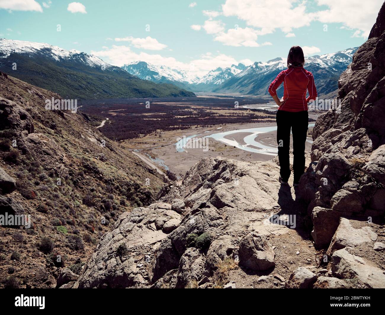 Vista posteriore di Woman su una roccia che ammira le viste sulle montagne, El Chalten, Argentina Foto Stock