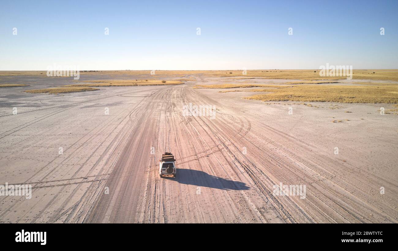Botswana, veduta aerea di un'auto 4x4 che attraversa la panna di Makgadikgadi Foto Stock