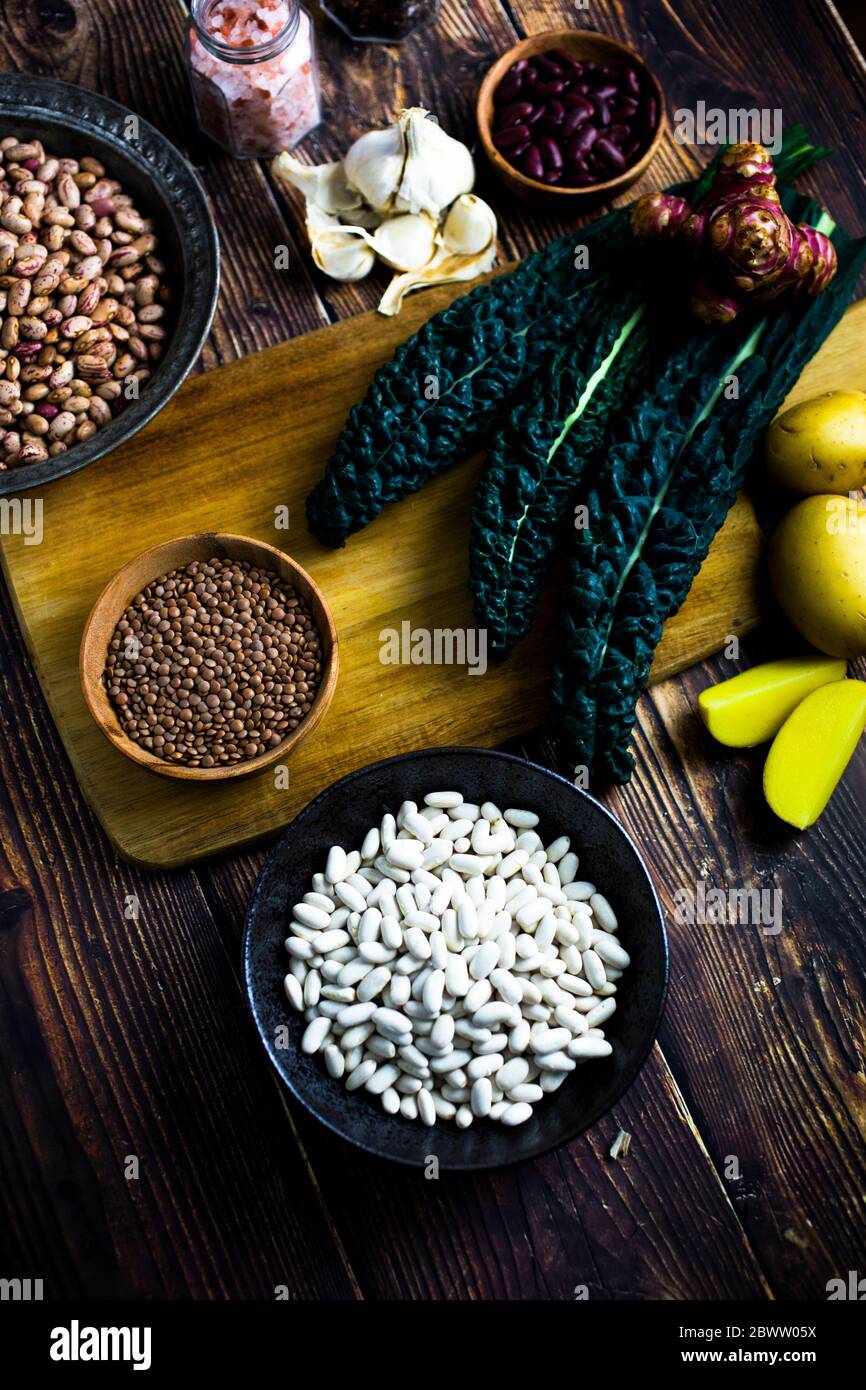 Cavolo nero, patate e ciotole di fagioli e lenticchie vari Foto Stock