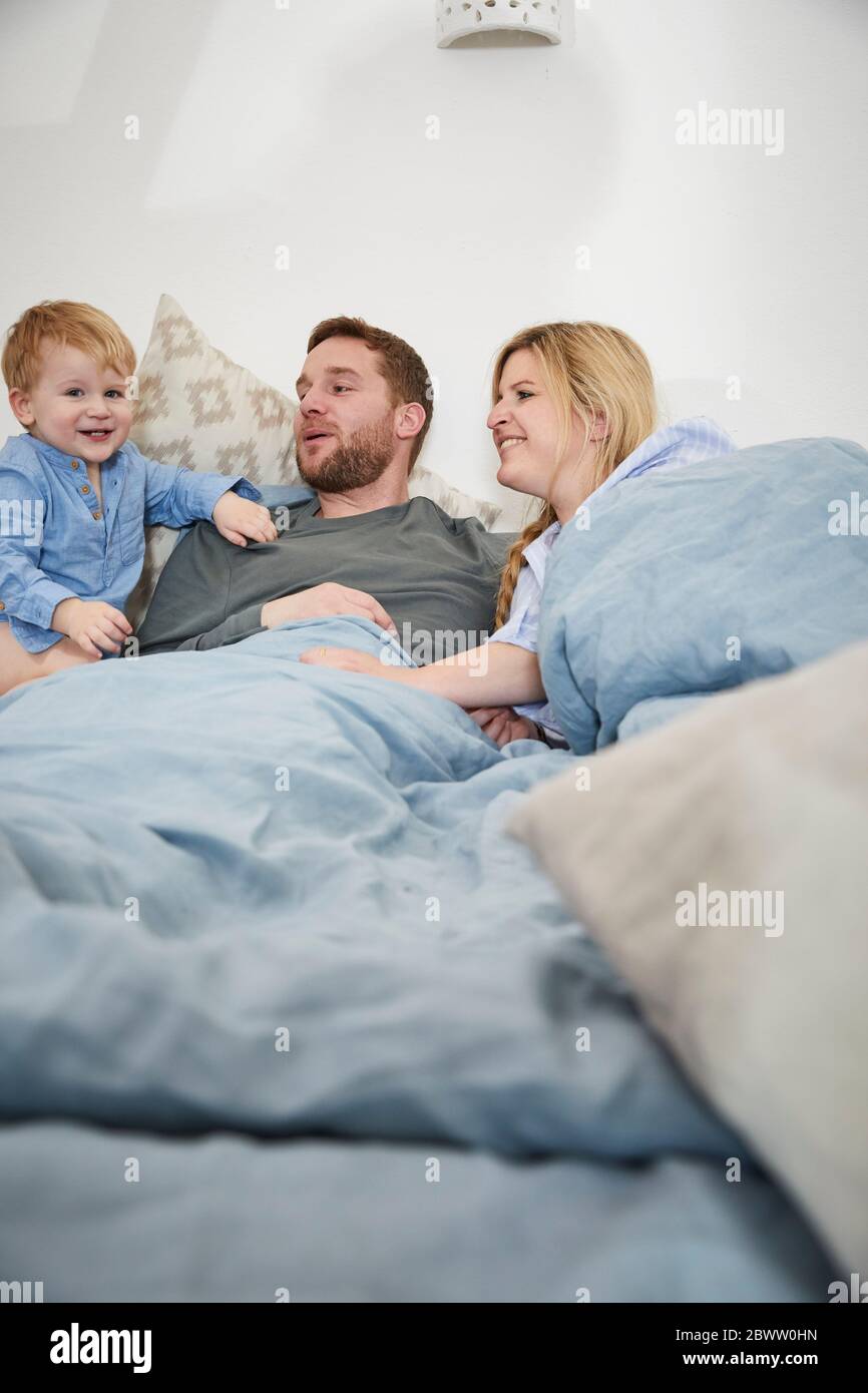 Famiglia insieme rilassante sul letto Foto Stock