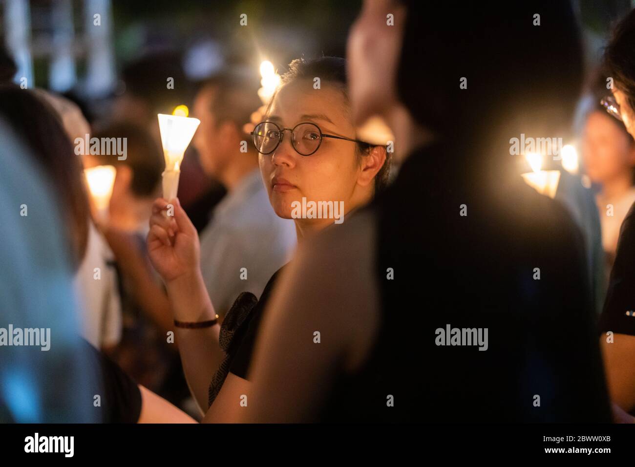 Una signora che appare triste durante una veglia a lume di candela per le vittime del massacro di Piazza Tiananmen a Victoria Park, Hong Kong - 4 giugno 2019 Foto Stock
