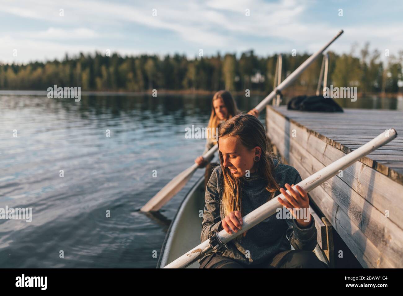 Due giovani donne che navigano sul lago Foto Stock