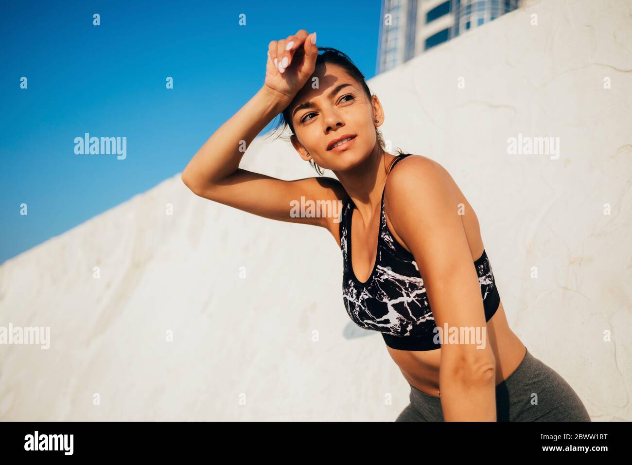 Atleta sfinito che si esercita all'aperto in giornata di sole Foto Stock