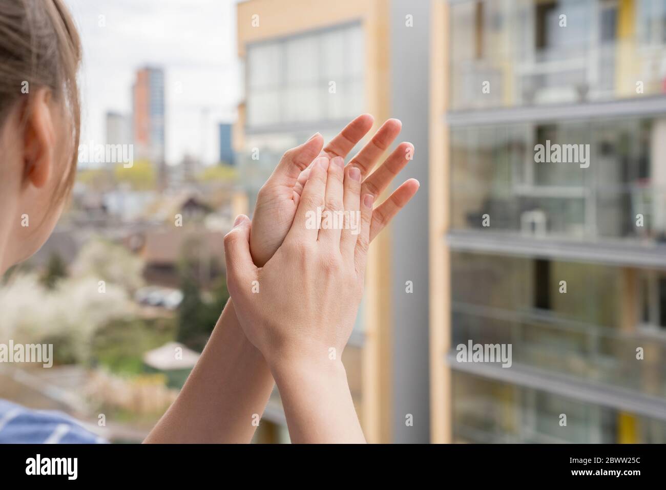 Vista di ritaglio di donna che si aggrappano le mani sul balcone Foto Stock