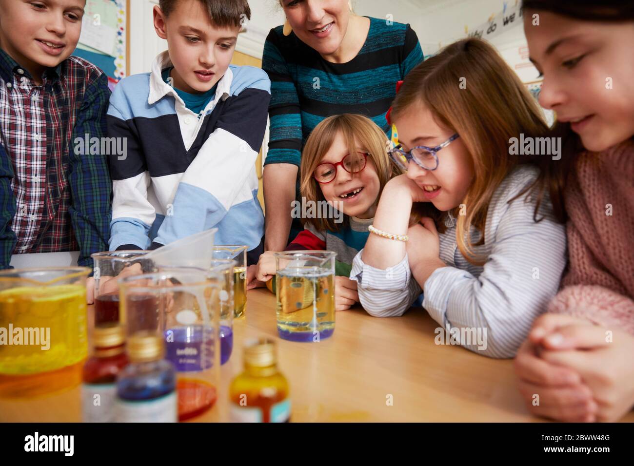 Gruppo di bambini con insegnante in una lezione di chimica scientifica Foto Stock