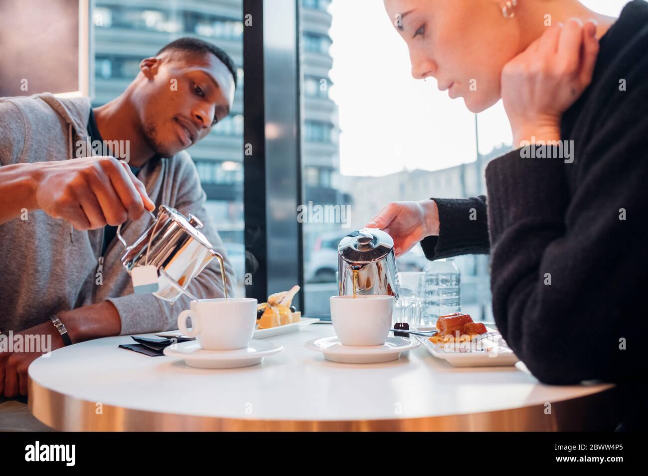 Giovane coppia in un caffè con torta e tè Foto Stock