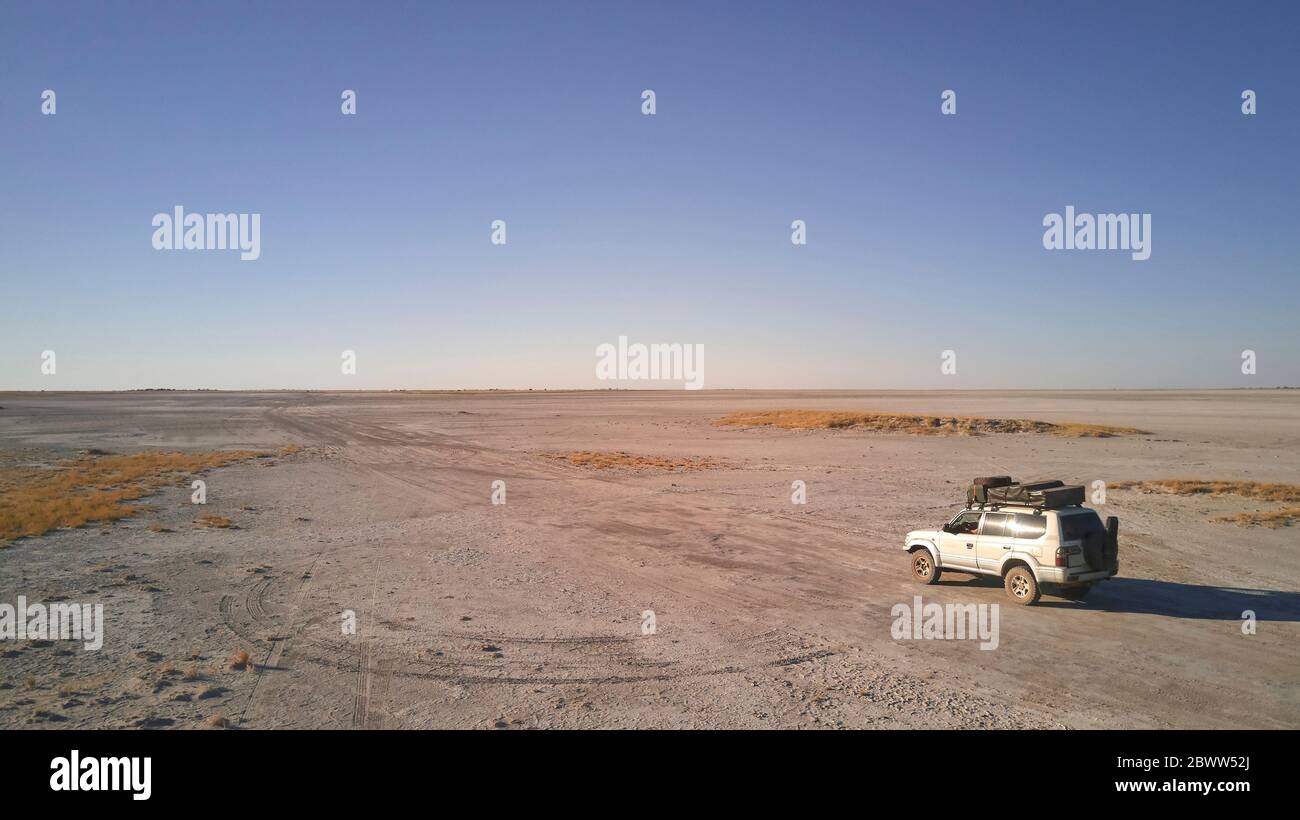 Botswana, veduta aerea di un'auto 4x4 che attraversa la panna di Makgadikgadi Foto Stock