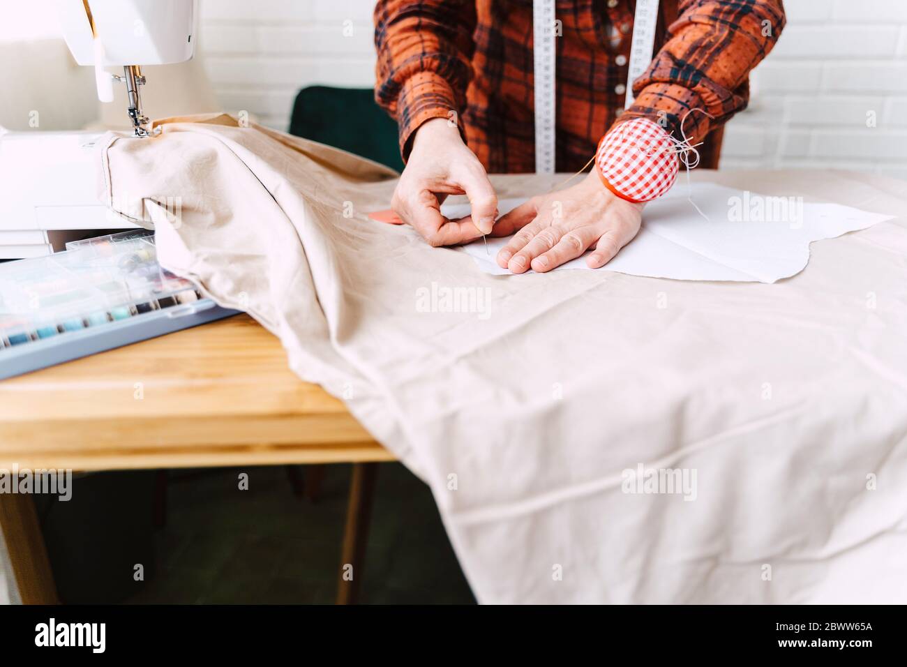 Primo piano di cucito cucito di pinning donna sul tavolo a casa Foto Stock