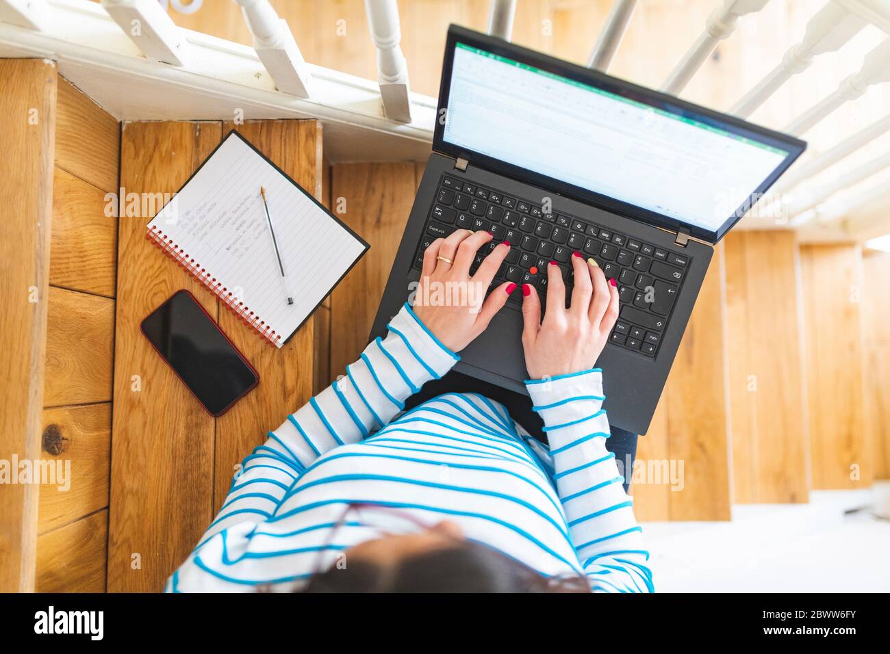 Donna che usa notebook, notebook e smartphone dall'alto Foto Stock