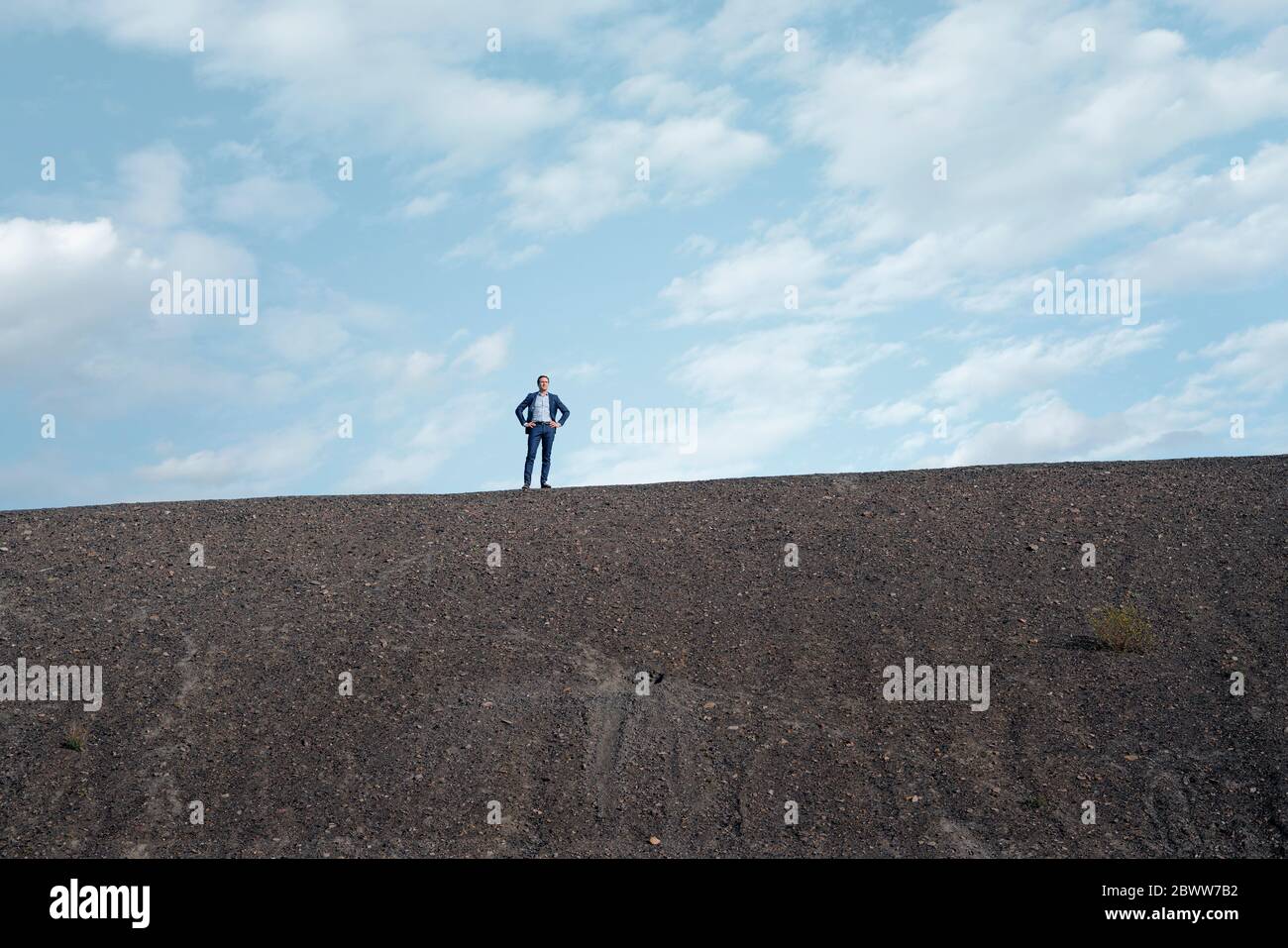 Uomo d'affari maturo in piedi su una punta di miniera disusata Foto Stock