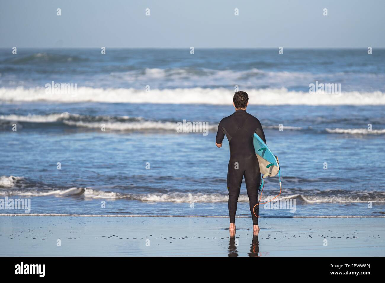 Surfista per disabili con surf in spiaggia Foto Stock