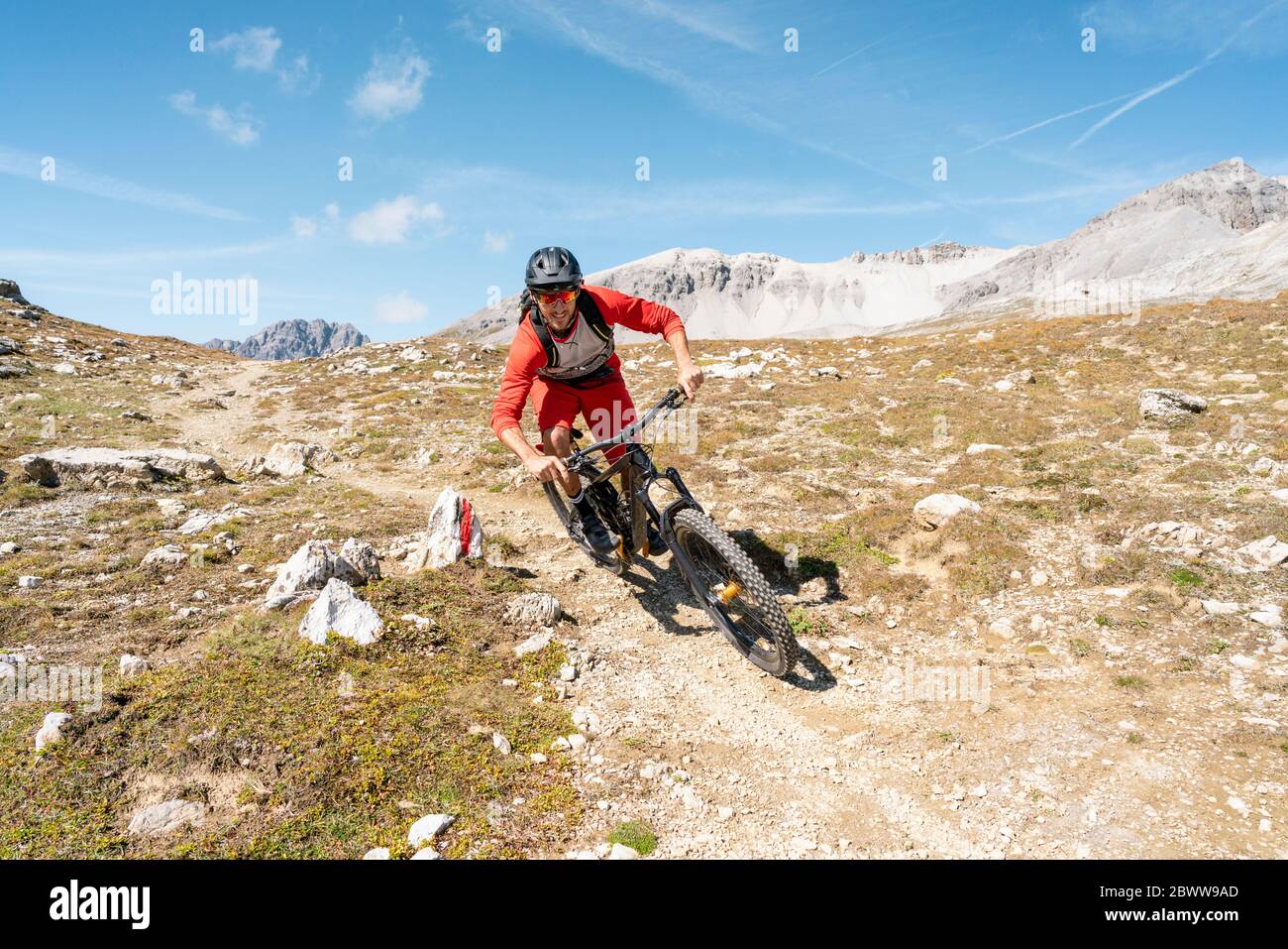 Uomo in mountain bike, Valle Munestertal, Grigioni, Svizzera Foto Stock