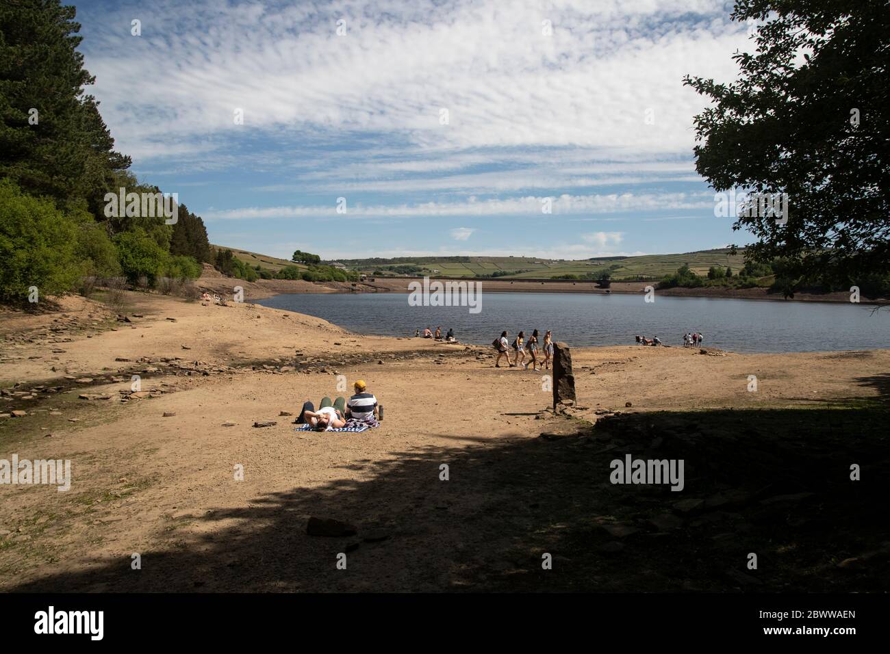 Turisti e residenti godono di sole estivo ai margini del Digley Reservoir, nel West Yorkshire, sotto il cielo blu Foto Stock