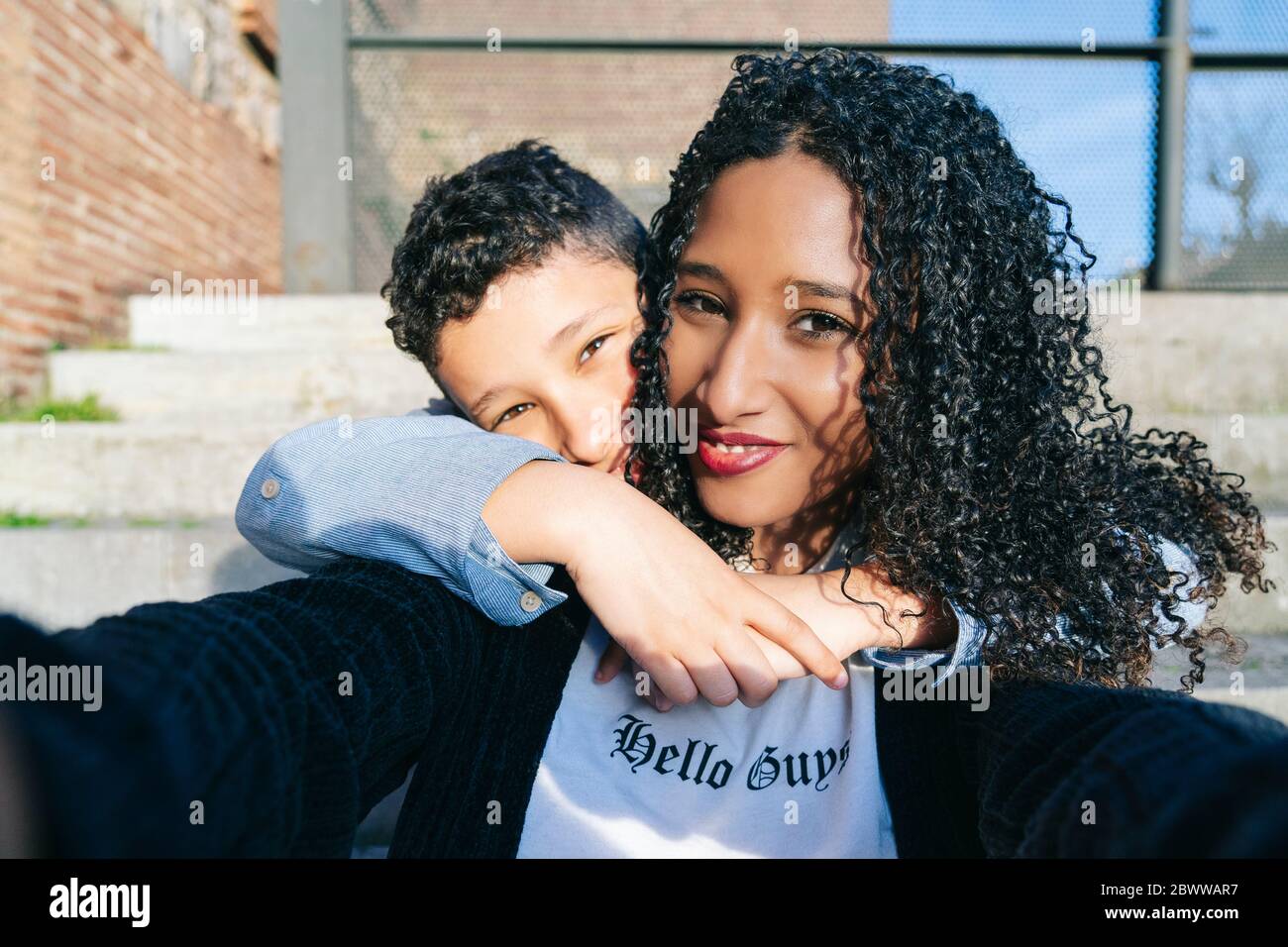 Ritratto di felice madre e figlio seduti insieme su passi prendendo selfie Foto Stock